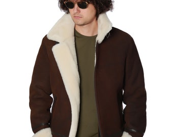 Puede incluir: Una chaqueta de piel de oveja marrón con cuello y forro de piel blanca. La chaqueta tiene cierre de cremallera y dos bolsillos. La persona que lleva la chaqueta lleva pantalones marrones y gafas de sol.