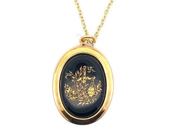 May include: Gold chain necklace with a black oval pendant featuring a gold image of the Libra zodiac sign.