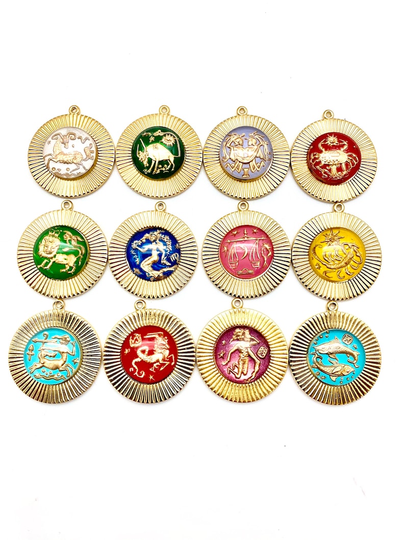 May include: Twelve gold-colored pendants with zodiac signs. Each pendant features a different zodiac sign with a colorful enamel background. The pendants are arranged in three rows of four.