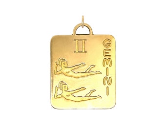 May include: Gold-colored pendant charm with a Roman numeral II and the word GEMINI in a vertical column. The charm features a stylized image of two figures lying side-by-side.