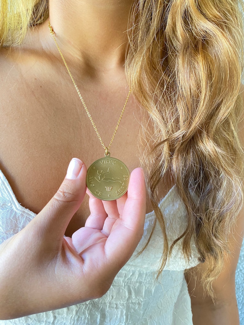 May include: Gold necklace with a round pendant featuring the Virgo zodiac sign and dates August 23 - September 22.