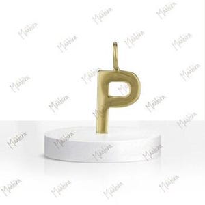 May include: A gold-toned metal pendant in the shape of the uppercase letter P, featuring a smooth, polished surface and a small circular loop at the top for attachment, presented as a single decorative jewelry component.