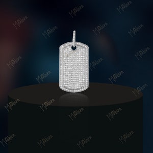May include: A silver pendant in the shape of a dog tag, completely covered in small, clear diamonds.