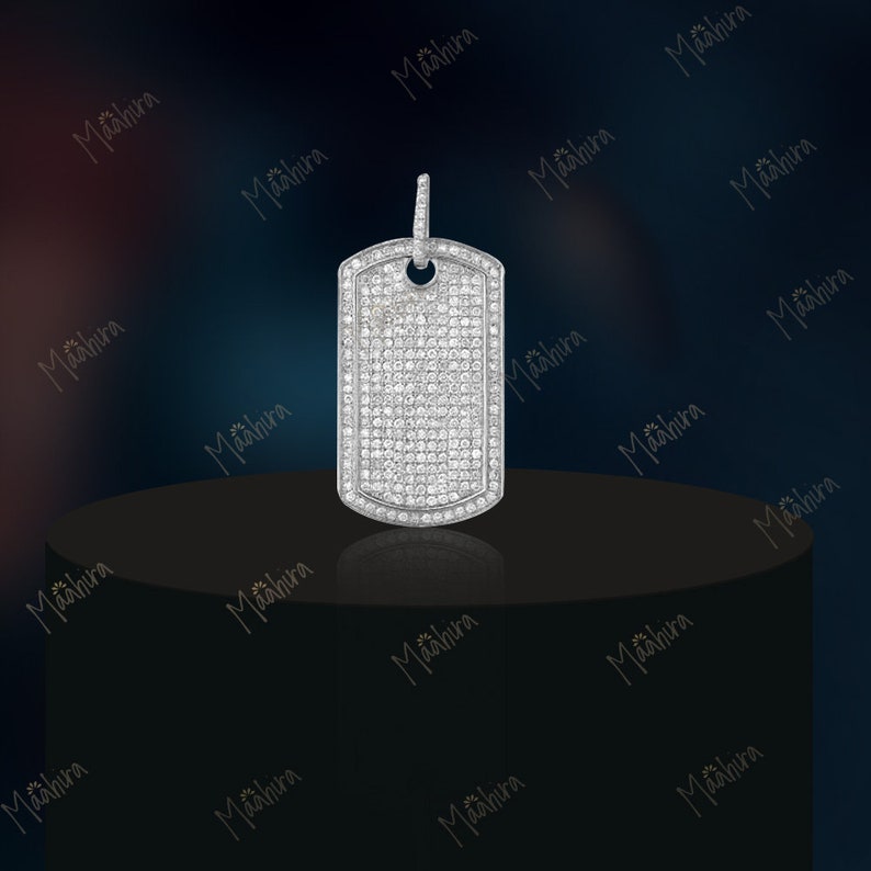 May include: A silver pendant in the shape of a dog tag, completely covered in small, clear diamonds.