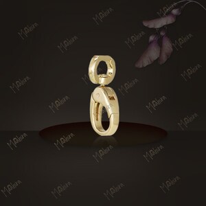 May include: A gold-toned metal swivel lobster clasp featuring a smooth, polished finish. The hardware consists of a circular top loop connected to a spring-loaded oval hook mechanism designed for secure attachment to various items or accessories.
