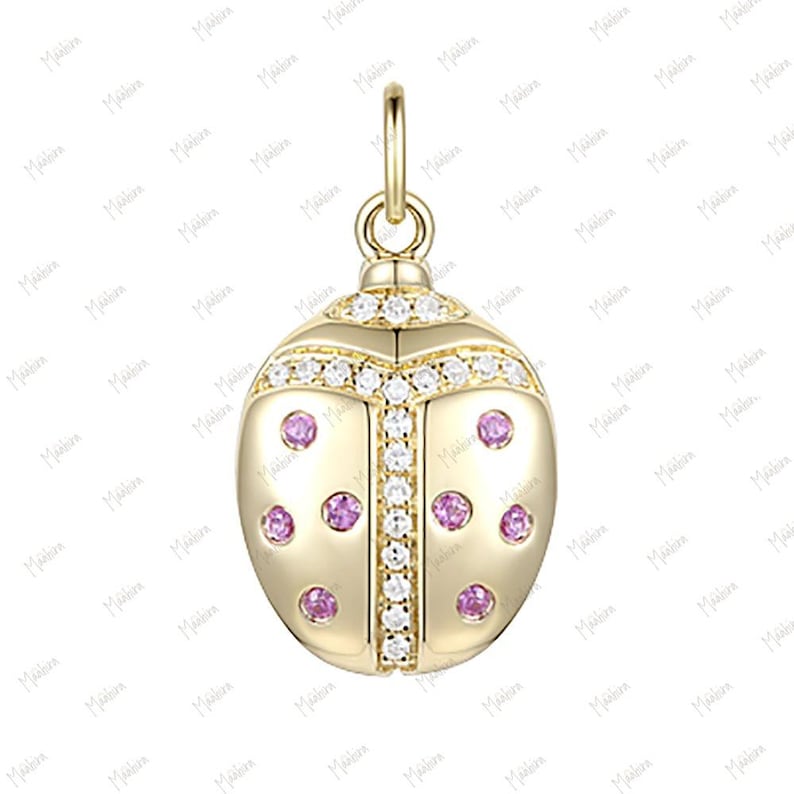 May include: A gold charm in the shape of a ladybug with pink and white stones.
