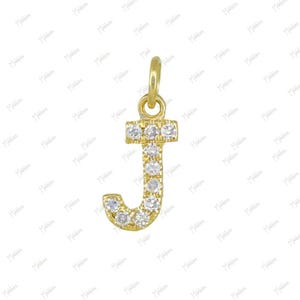May include: A gold letter J pendant featuring a series of small, clear, round-cut stones embedded along the front surface of the letter. The pendant includes a small, circular gold bail at the top for attachment to a chain or necklace.