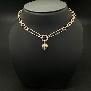May include: A gold chain necklace with a round charm featuring a ladybug design with small diamonds. The chain is made of thick, linked metal.