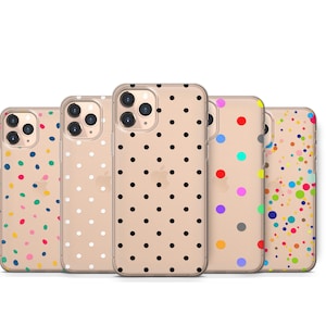 Puede incluir: Cinco fundas para iPhone con patrones de lunares. Las fundas son transparentes y muestran las lentes de la cámara del teléfono. Los patrones incluyen lunares negros sobre blanco, lunares blancos sobre dorado, lunares arcoíris sobre blanco, lunares azules y verdes sobre blanco, y lunares grises y rosas sobre blanco.