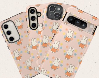 May include: Four phone cases with a repeating pattern of a white rabbit wearing an orange dress, surrounded by small flowers on a pink background. The word "MIFFY" is written in orange bubble letters at the top.