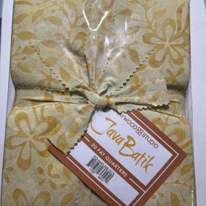 May include: A package of 20 fat quarter fabric squares in a yellow and white floral pattern. The fabric is labeled "Java Batik" and "Maywood Studio".