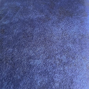 May include: A close-up of a dark blue fabric with a textured surface.