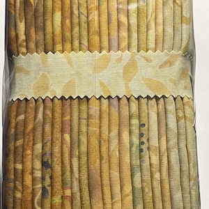 May include: A bundle of fabric strips in various shades of brown, yellow, and beige with a floral pattern. The fabric is wrapped in a white label with a scalloped edge.