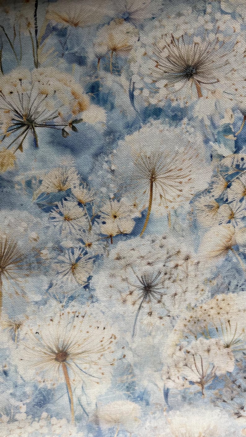 以下が含まれることがあります： 白タンポポの種子と繊細な花が、水彩画風の淡い青と白の背景に繰り返されるパターンを持つ生地。このデザインは、自然と静けさを連想させます。
