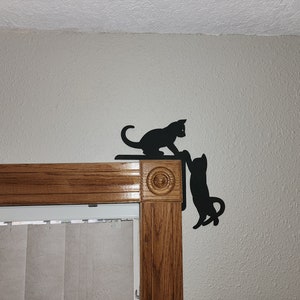 Kunst aan de muur, spelende katten, deurhoek