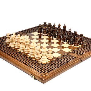 May include: A wooden chess set with detailed carved borders. The chessboard has a light and dark square pattern, with chess pieces arranged for play. The pieces are in light and dark wood tones.