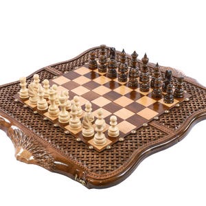 May include: A wooden chess set with a decorative, woven border. The chessboard features light and dark squares, with chess pieces arranged for play. The set includes light and dark chess pieces. The board is approximately 18 inches square.