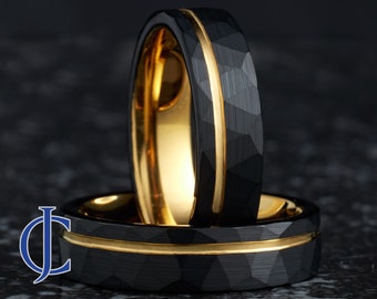 Puede incluir: Dos anillos de carburo de tungsteno negro con una incrustación de oro. Los anillos tienen un acabado martillado.