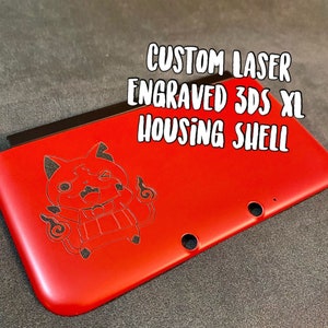 May include: A red custom laser engraved 3DS XL housing shell. The shell features a black engraved cartoon character. The text "CUSTOM LASER ENGRAVED 3DS XL HOUSING SHELL" is displayed in white.