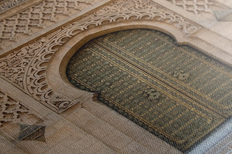 Puede incluir: Primer plano de una impresi&oacute;n en lienzo que representa una puerta arqueada con un marco de piedra tallada intrincadamente. La puerta es de un verde apagado con un patr&oacute;n texturizado, y la piedra circundante es de un beige c&aacute;lido.