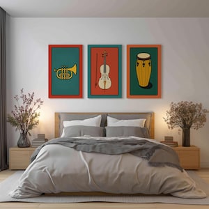 May include: Three framed art prints depicting musical instruments: a trumpet, a violin, and a conga drum. Each print has a colourful design with a red border and a teal, orange, or green background. The prints are displayed above a bed.