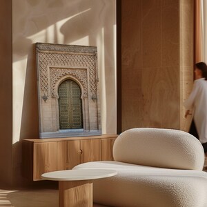 Puede incluir: Una impresi&oacute;n en lienzo enmarcada de una puerta arqueada ornamentada con intrincadas tallas y una puerta de lat&oacute;n. La impresi&oacute;n se exhibe sobre un mueble de madera clara, con un sof&aacute; blanco y una peque&ntilde;a mesa redonda en primer plano. La habitaci&oacute;n tiene una paleta de colores c&aacute;lidos y neutros.