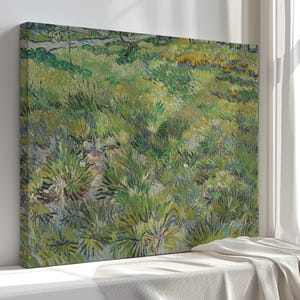 Op de afbeelding: Een canvas print van een landschapsschilderij met een veld met groen en geel gras. Het kunstwerk heeft een textuur, impressionistische stijl met zichtbare penseelstreken. Het schilderij is geplaatst tegen een neutrale achtergrond.