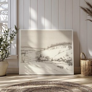 May include: A black and white drawing of a snowy landscape with a small village in the distance. The drawing is framed in a white frame.