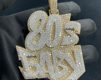 May include: A gold pendant with the words "80z Baby" set in diamonds. The pendant is made by Jalash.