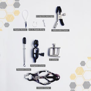 K&ouml;nnte beinhalten: Ein Set aus Klemmen und Ringen f&uuml;r K&ouml;rperpiercings. Das Set enth&auml;lt eine Vielzahl von Klemmen, darunter eine C-Klemme, eine Alligator-Klemme, eine Pinzette und eine Kleeblatt-Klemme. Au&szlig;erdem gibt es einen Nippelring, eine Nippel-Schlinge und einen O-Ring.