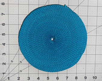 May include: A roll of teal blue webbing with a white stripe. The webbing is rolled into a circle and is about 7 inches in diameter.