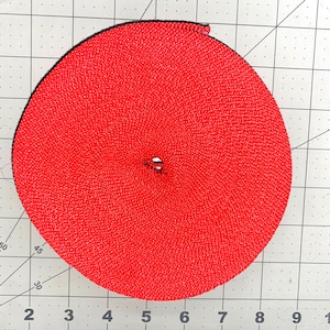 Puede incluir: Un rollo de cinta roja brillante, probablemente utilizado para manualidades o proyectos de bricolaje.