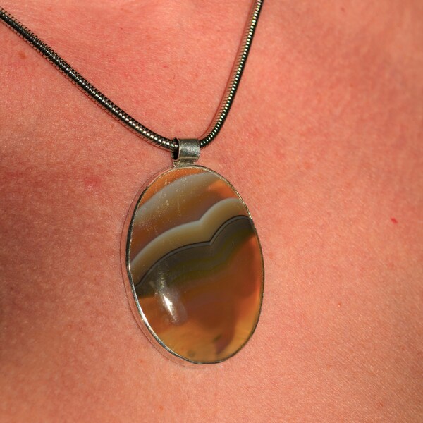 Special pendant with a Montana Agate in a sterling silver frame with clover four image. Pendant size: 47.5 x 31.2 mm.