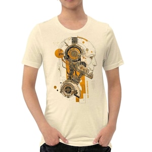 Könnte beinhalten: Cremefarbenes T-Shirt mit einer detaillierten Illustration eines Roboter-Kopfes in Orange, Braun und Beige. Das Design umfasst mechanische Komponenten und architektonische Elemente. Der Text "ORANGECLOUD90.COM" ist auf dem Design sichtbar.