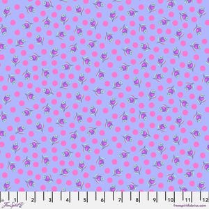May include: A light purple fabric with a repeating pattern of pink polka dots and small purple flowers with green stems. The fabric has a ruler printed at the bottom with inches marked.