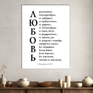 May include: A framed white print with black text in a decorative font. The text is in Russian and includes the word "Love" in large letters. The print is displayed on a wooden shelf with decorative items.