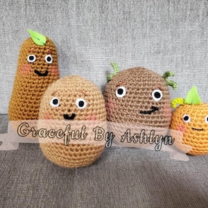 May include: Four crocheted plush potatoes with smiling faces. The potatoes are brown, tan, and orange. The potatoes have green leaves on top. The potatoes are sitting on a gray couch. The text "Graceful By Ashlyn" is on a white ribbon in front of the potatoes.