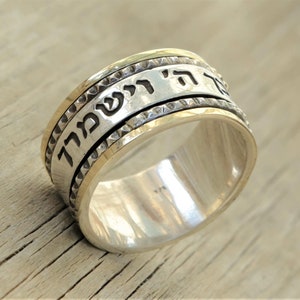 May include: A silver and gold spinning ring with Hebrew text that reads "Ani L'Dodi V'Dodi Li" which translates to "I am my beloved's and my beloved is mine".