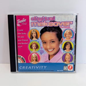 May include: A Barbie Digital Makeover CD-ROM software case featuring a pink side panel with text and a blue main panel displaying a smiling person surrounded by circular portraits of various individuals. The cover includes the title text and an E rating.