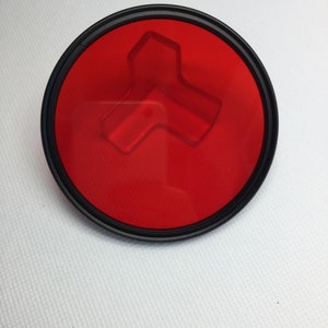 Peut inclure: Un filtre pour objectif d'appareil photo de couleur rouge avec un bord noir.