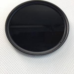 May include: A black camera lens filter with a 60mm diameter.