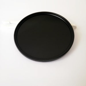 May include: A black round camera lens filter with a threaded edge.