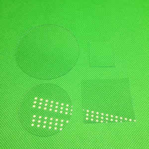 May include: Four clear glass pieces on a green background. The pieces are a circle, a square, and two smaller circles with a pattern of small white dots.