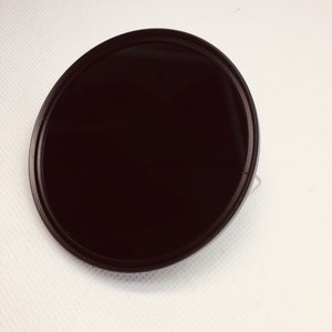 May include: A black circular camera lens filter with a thin silver rim.