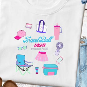 Peut inclure: T-shirt blanc avec un motif coloré d'articles de voyage, dont une casquette rose, des lunettes de soleil, un sac, une gourde, un éventail, une jupe, une chaise, une glacière et un téléphone. Le texte dit "Travel Ball mom STARTER PACK".