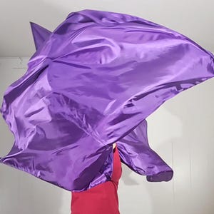 May include: A purple worship flag made of silky fabric, flowing in the air.
