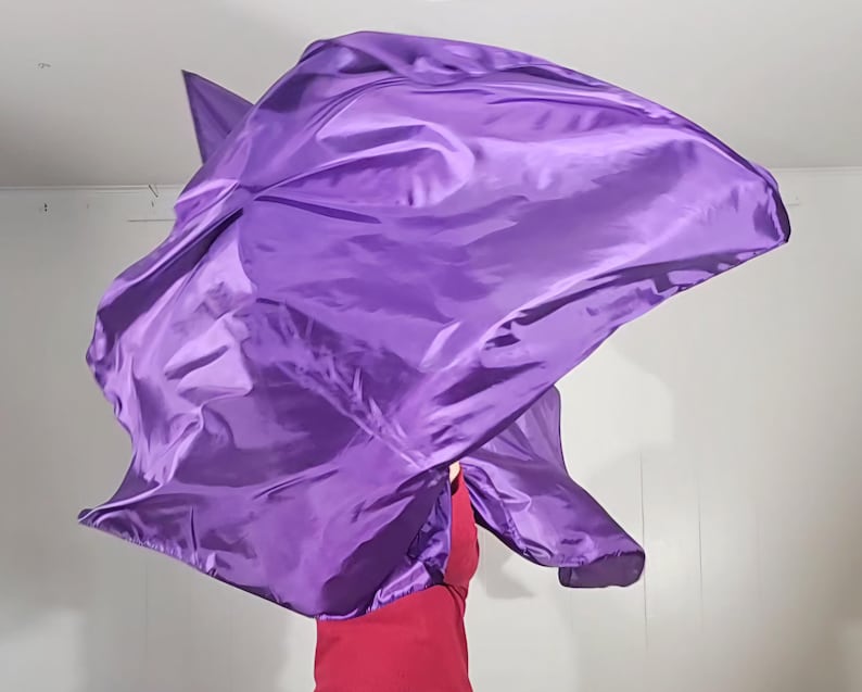 May include: A purple worship flag made of silky fabric, flowing in the air.