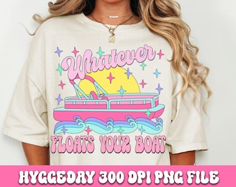 May include: A white t-shirt with a pink, blue, and yellow graphic design. The graphic features a boat with waves and stars, and the text "Whatever Floats Your Boat".