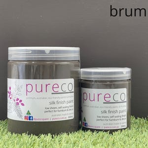 May include: Two jars of "pureco" silk finish paint in a dark grey colour, labelled "brumby". The larger jar contains 600ml, and the smaller jar contains 200ml. The labels include text about the paint's features and origin.