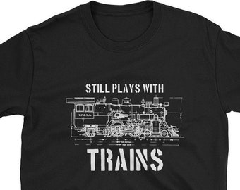 Op de afbeelding: Zwart T-shirt met een witte afbeelding van een trein en de tekst "Still Plays With Trains".